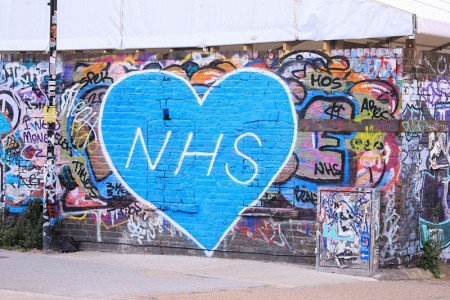 NHS graffiti on a brick graffitied wall