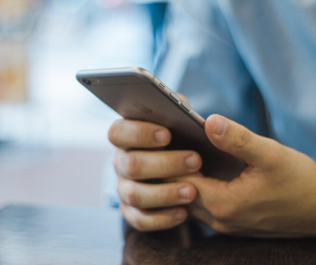 A person holding a mobile phone.png