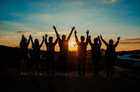 A group of young people with their hands in the air in front of a sunset. Credit Pixabay.com-3614311.jpg