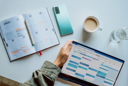 A planner, mobile phone and tablet on a table