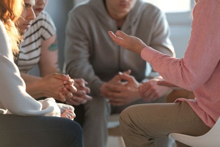 A group of 4 people sat on chairs in a circle